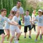 Children joyfully running and holding hands in a sunny park, enjoying outdoor recreation.